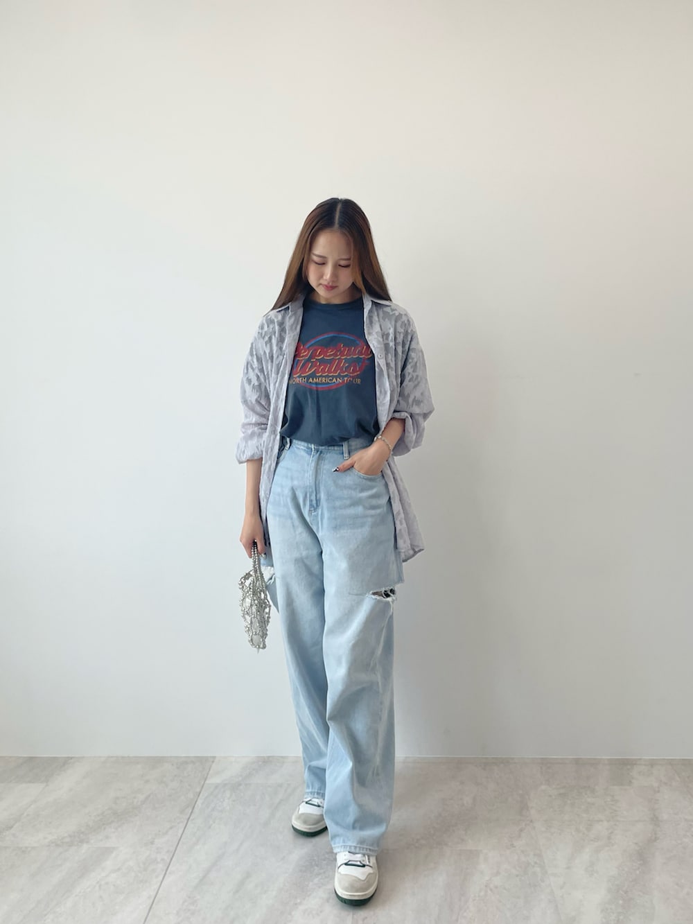 グレー系のシャツ/ブラウス、ブルー系のデニムパンツ、ホワイト系のスニーカーを着用したレディースの夏コーディネートの2枚目の写真