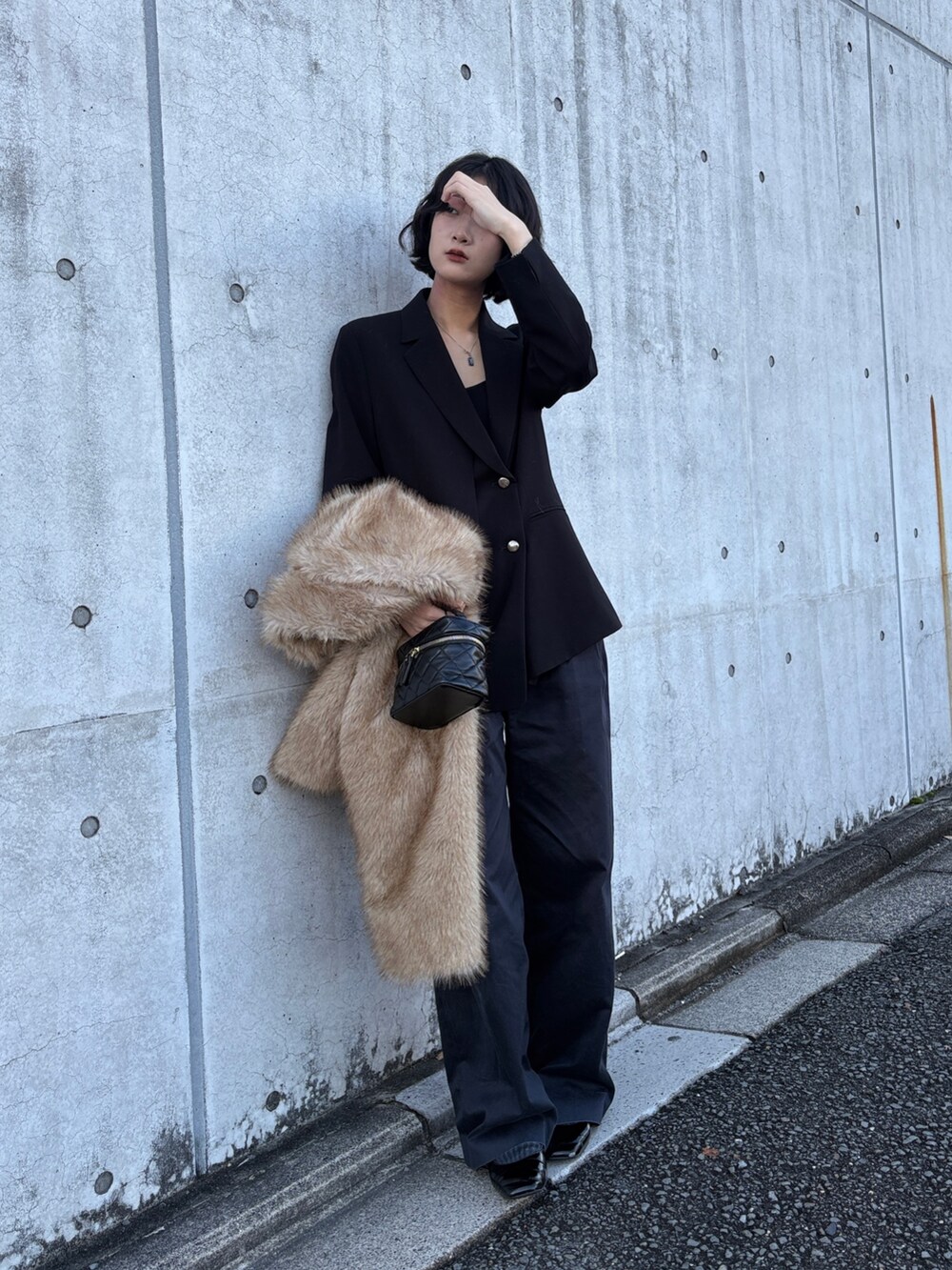 ブラック系のテーラードジャケット、ブラウン系のその他アウターを着用したレディースの冬コーディネートの2枚目の写真