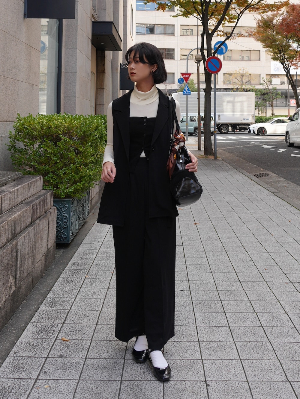 ブラック系のスーツセットを着用したレディースの冬コーディネートの2枚目の写真