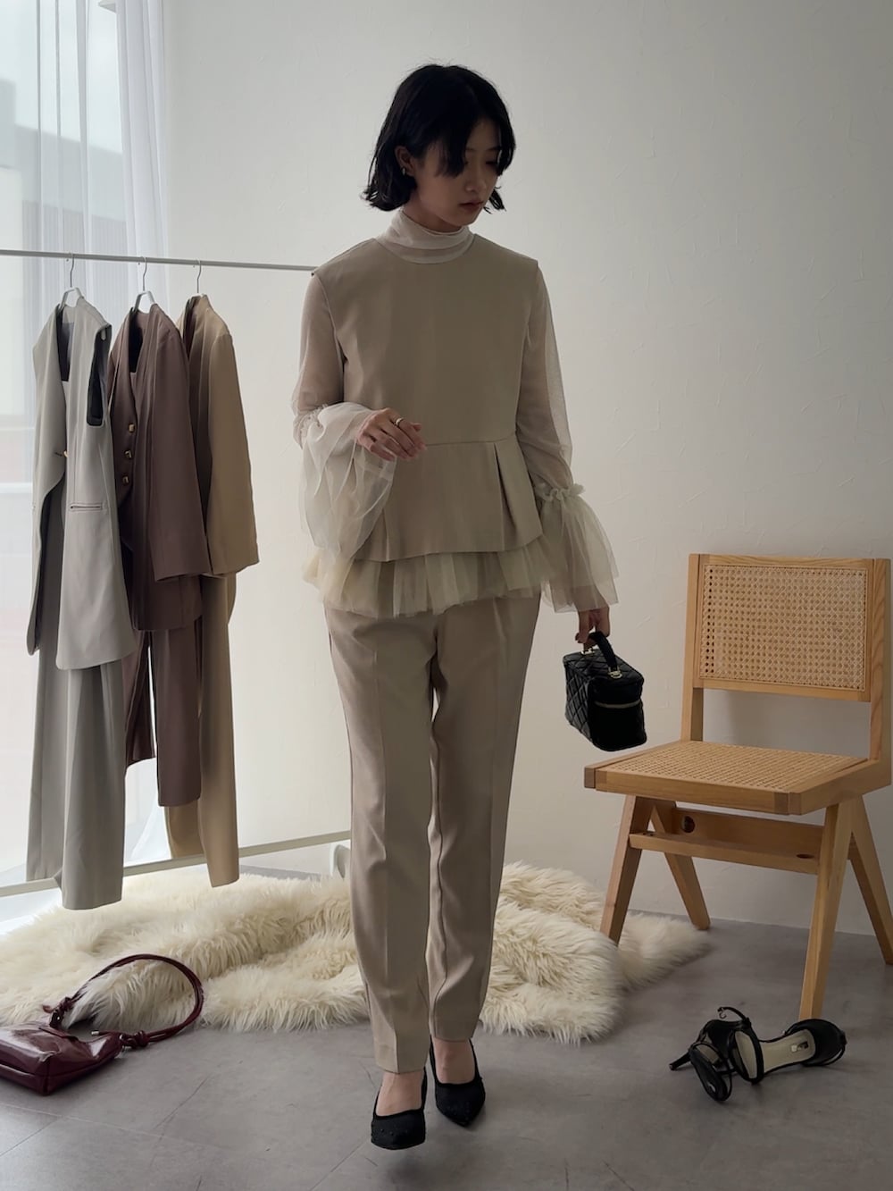 ベージュ系のパンツドレス、ホワイト系のシャツ/ブラウスを着用したレディースの冬コーディネートの2枚目の写真