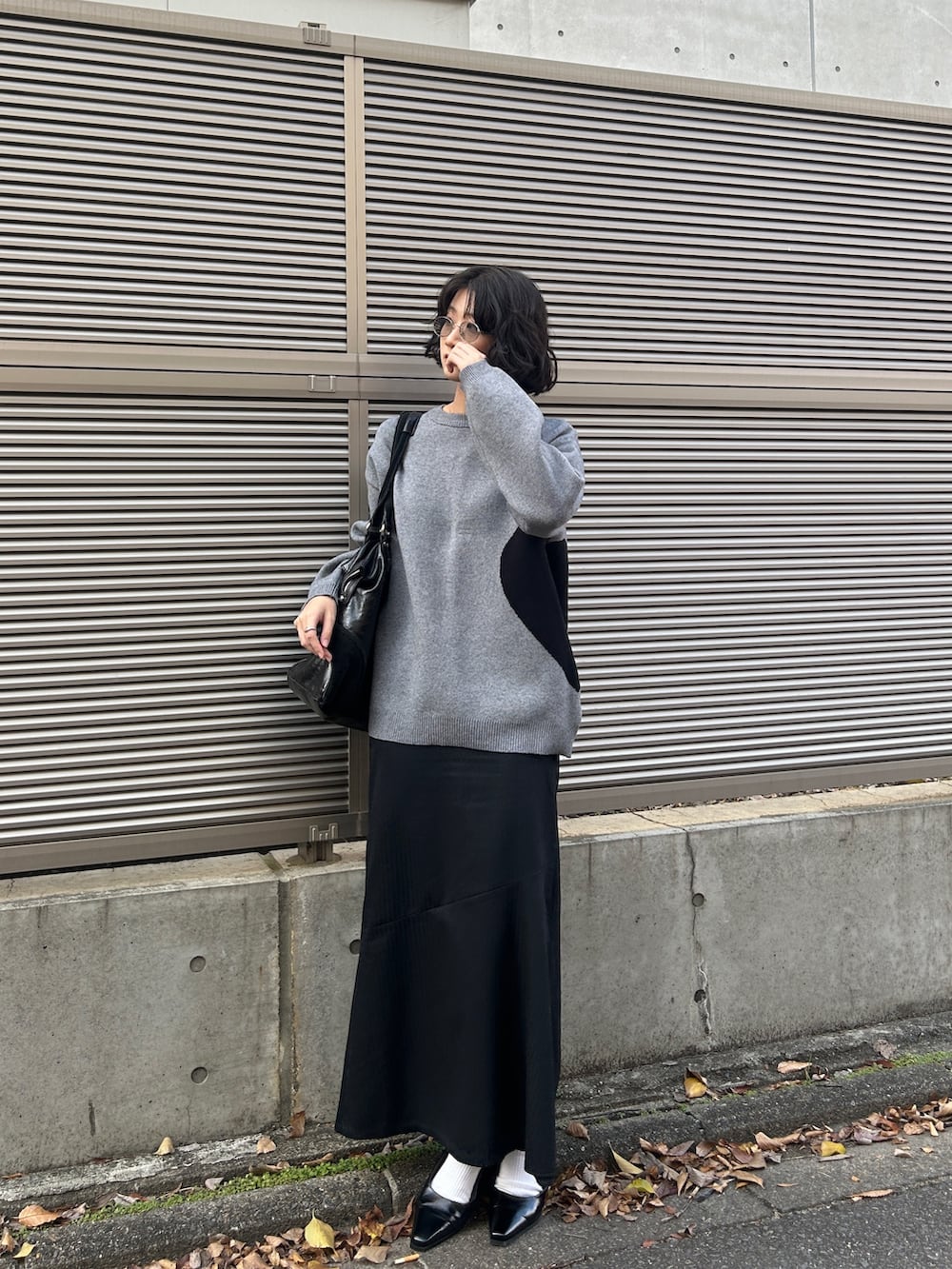 グレー系のニット/セーター、ブラック系のパンプスを着用したレディースの秋コーディネートの5枚目の写真