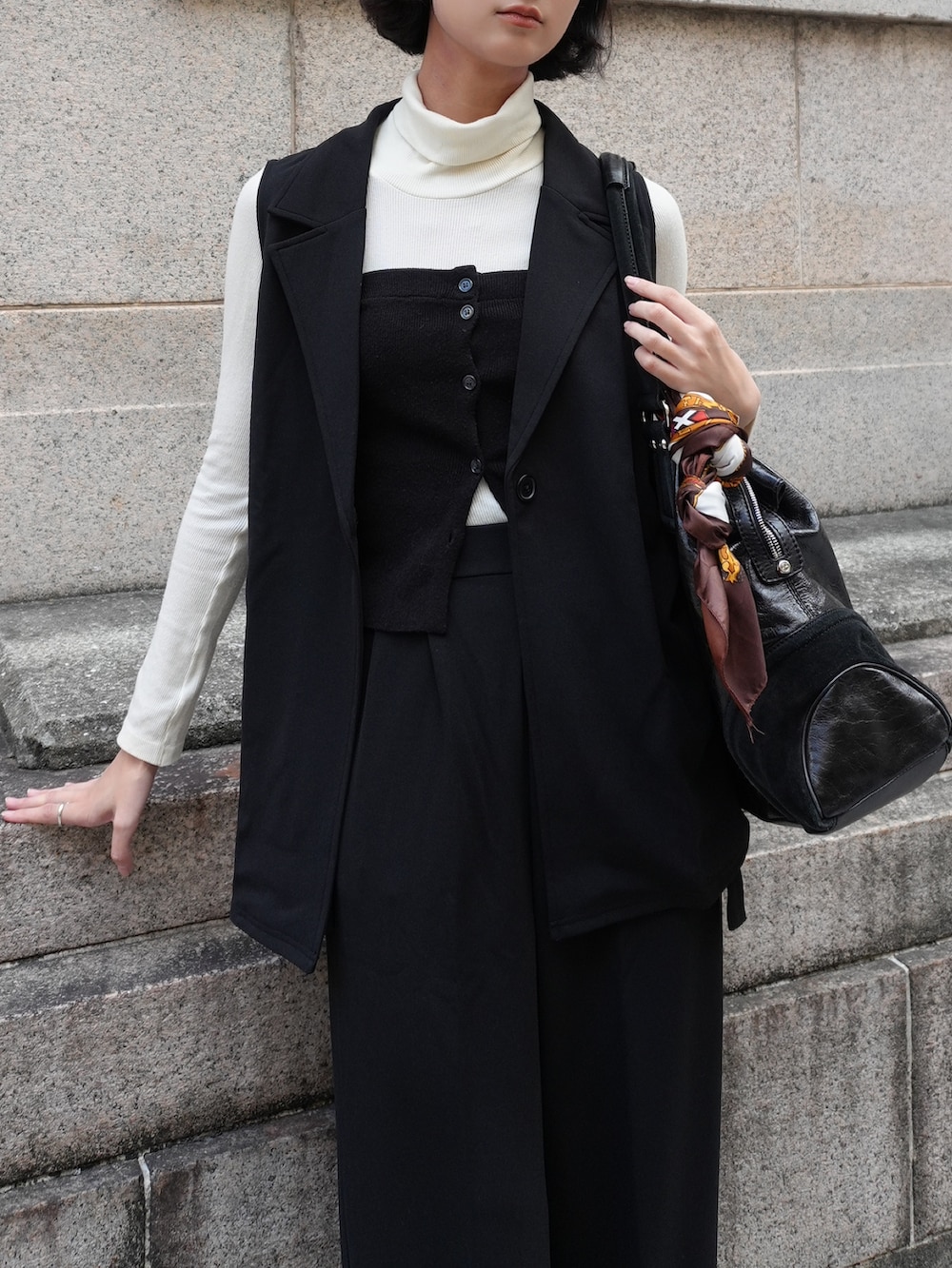 ブラック系のスーツセットを着用したレディースの冬コーディネートの3枚目の写真