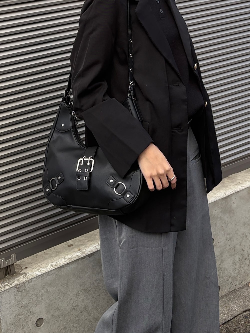 ブラック系のテーラードジャケット、ブラック系のニット/セーター、グレー系のスラックスを着用したレディースの冬コーディネートの4枚目の写真