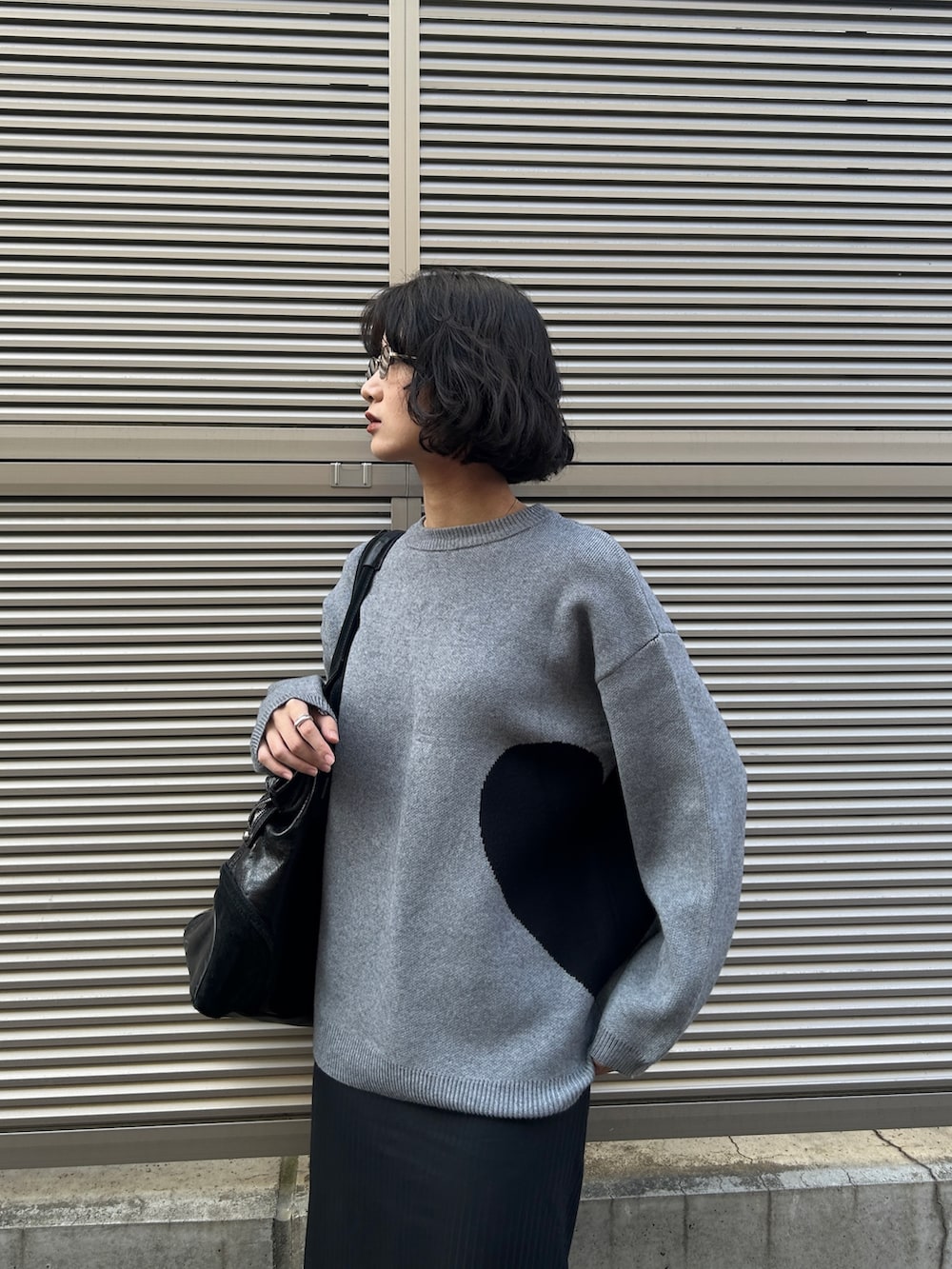 グレー系のニット/セーター、ブラック系のパンプスを着用したレディースの秋コーディネートの3枚目の写真