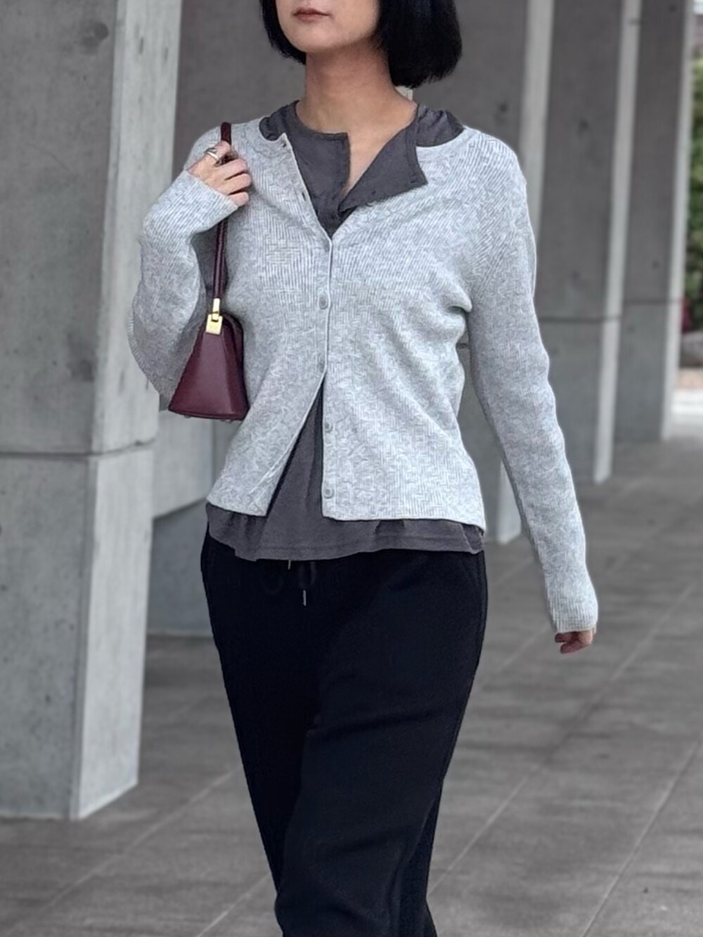 グレー系のニット/セーター、ブラック系のスウェットパンツを着用したレディースの春コーディネートの3枚目の写真