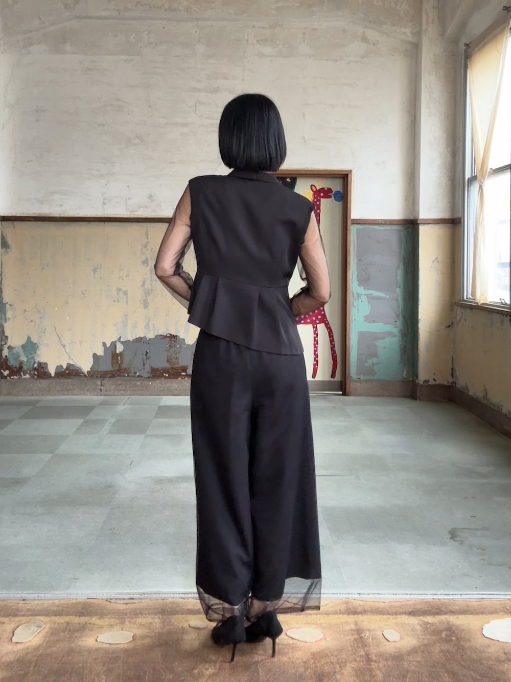 ブラック系のパンツドレスを着用したレディースの冬コーディネートの4枚目の写真