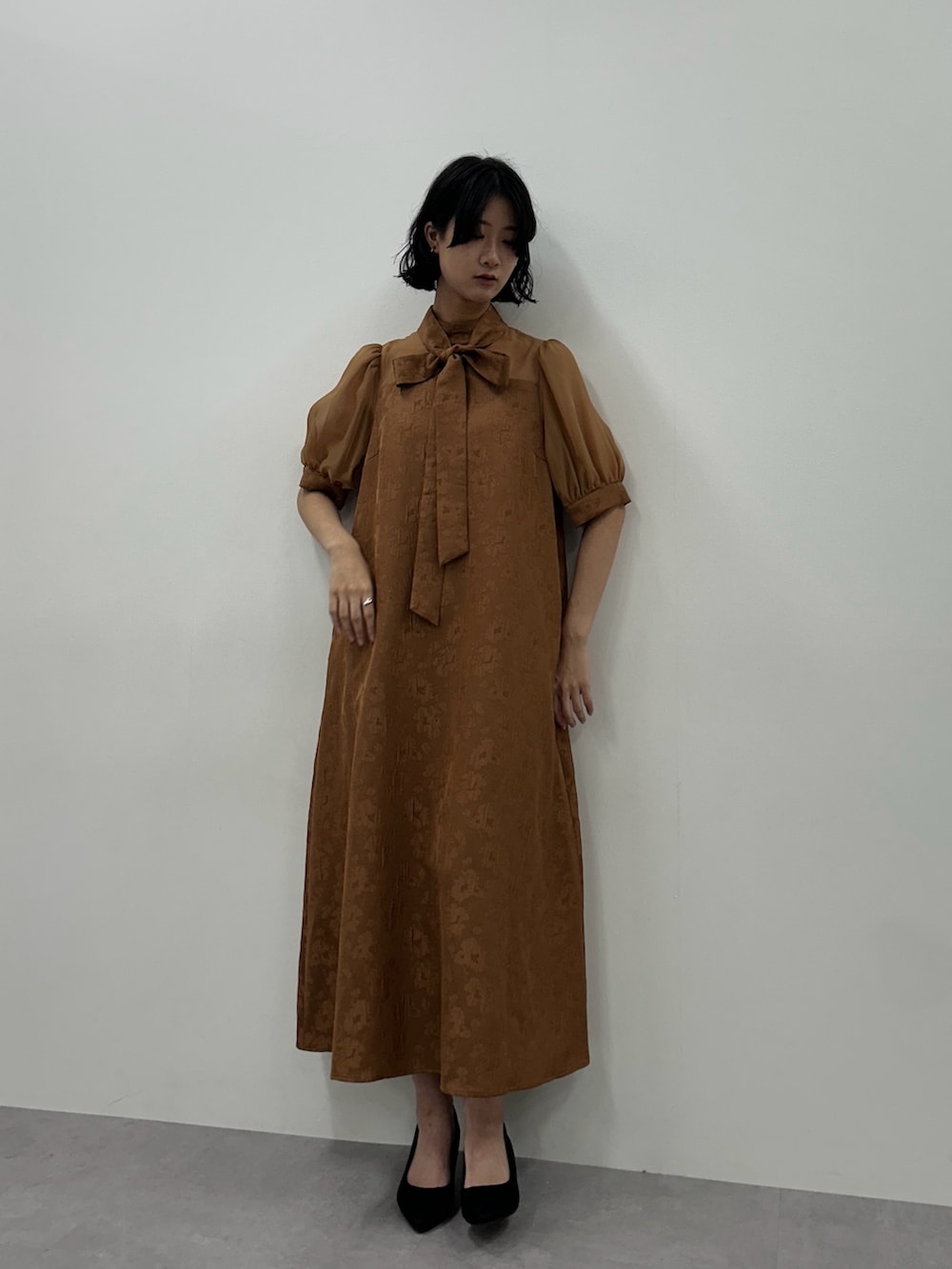 ブラウン系のドレスを着用したレディースの秋コーディネートの2枚目の写真