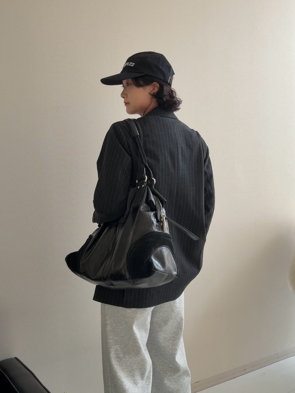 グレー系のジャケット/アウター、ブラック系のスニーカー、グレー系のスウェットパンツを着用したレディースの秋コーディネートの4枚目の写真