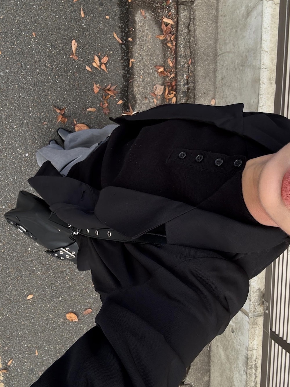 ブラック系のテーラードジャケット、ブラック系のニット/セーター、グレー系のスラックスを着用したレディースの冬コーディネートの6枚目の写真