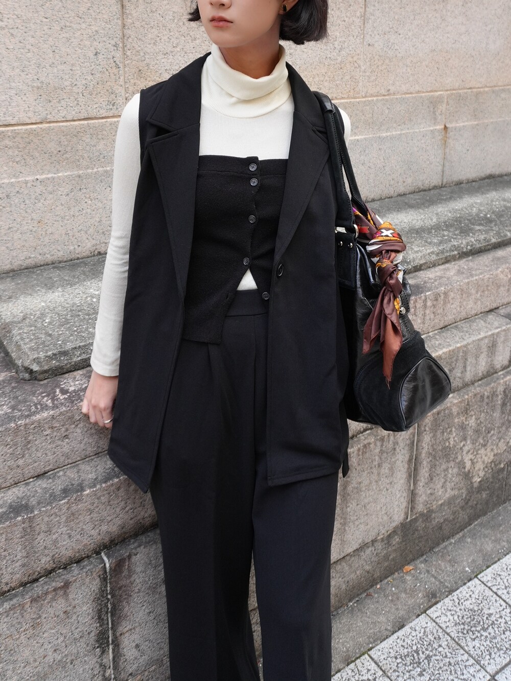 ブラック系のスーツセットを着用したレディースの冬コーディネートの4枚目の写真