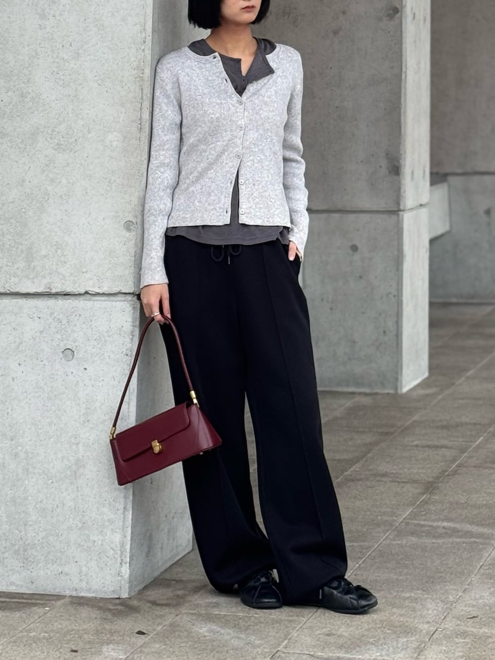 グレー系のニット/セーター、ブラック系のスウェットパンツを着用したレディースの春コーディネートの2枚目の写真