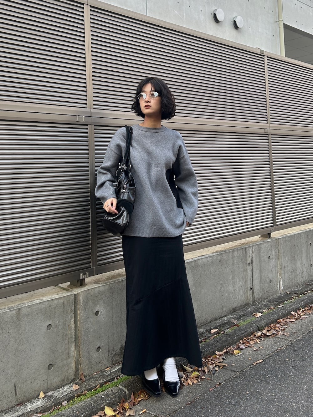 グレー系のニット/セーター、ブラック系のパンプスを着用したレディースの秋コーディネートの2枚目の写真