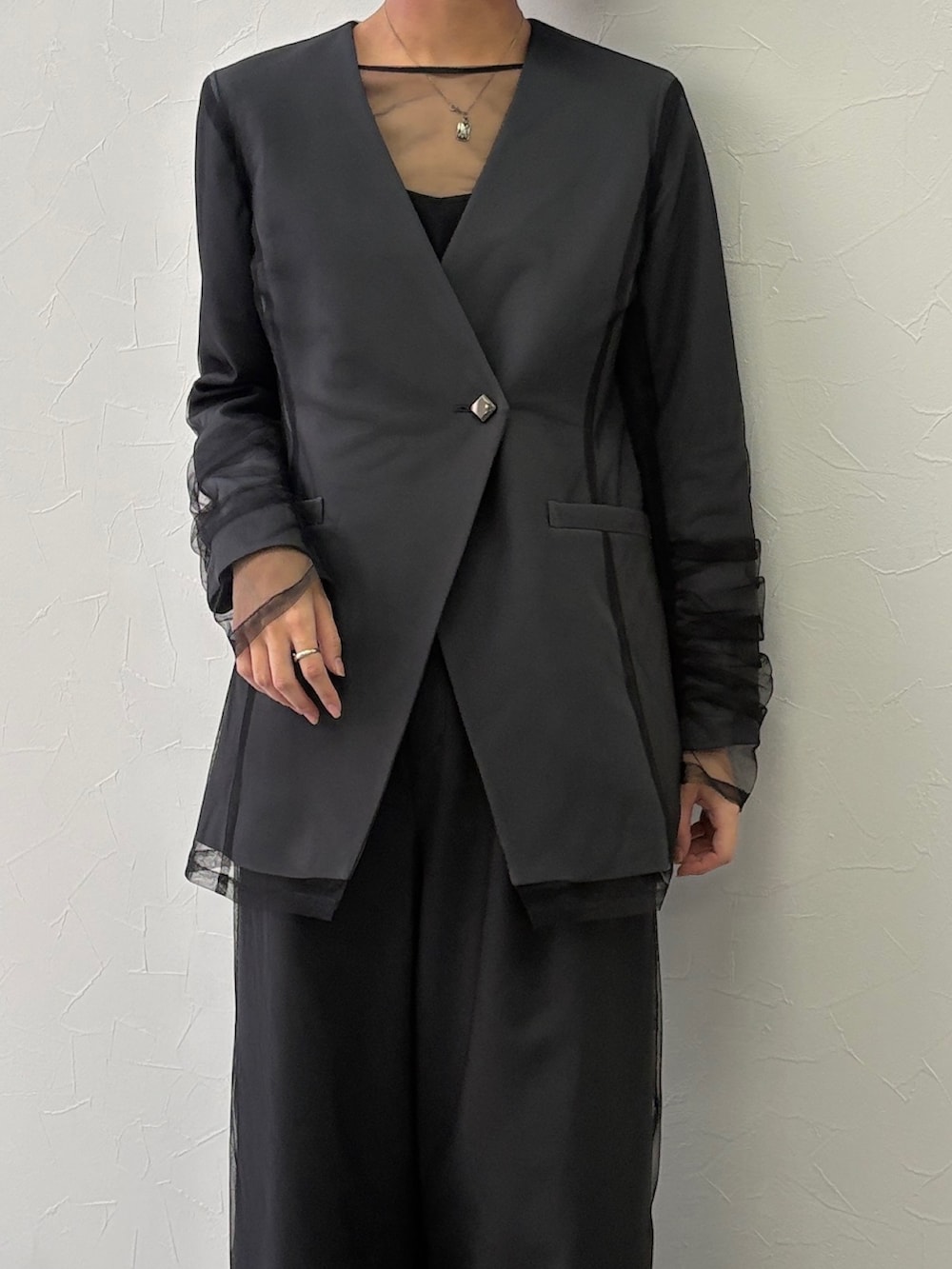 グレー系のノーカラージャケット、グレー系のその他パンツを着用したレディースの秋コーディネートの2枚目の写真