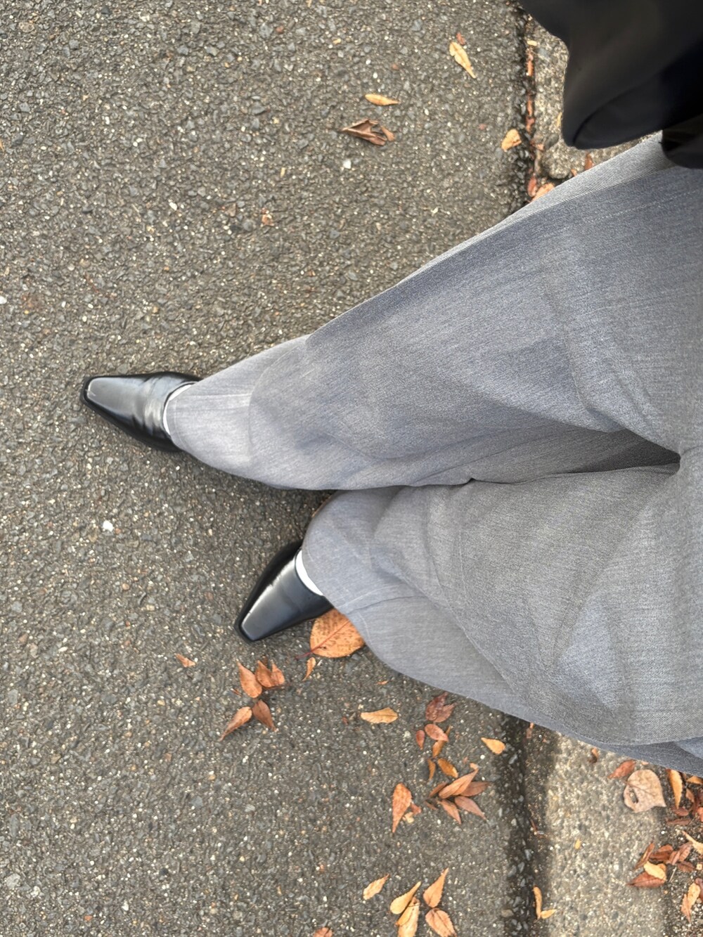 ブラック系のテーラードジャケット、ブラック系のニット/セーター、グレー系のスラックスを着用したレディースの冬コーディネートの5枚目の写真