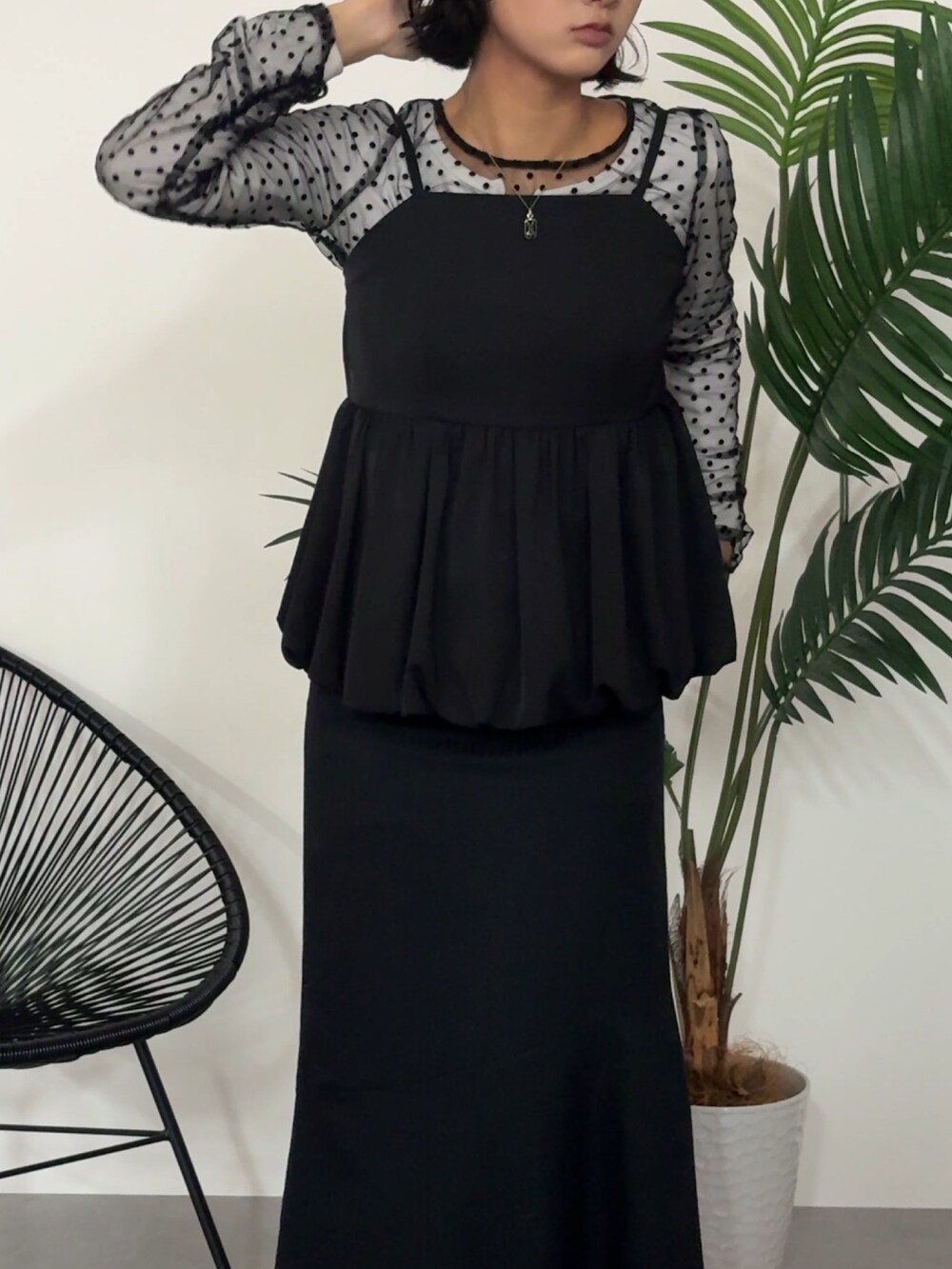 ブラック系のパンツドレスを着用したレディースの秋コーディネートの2枚目の写真