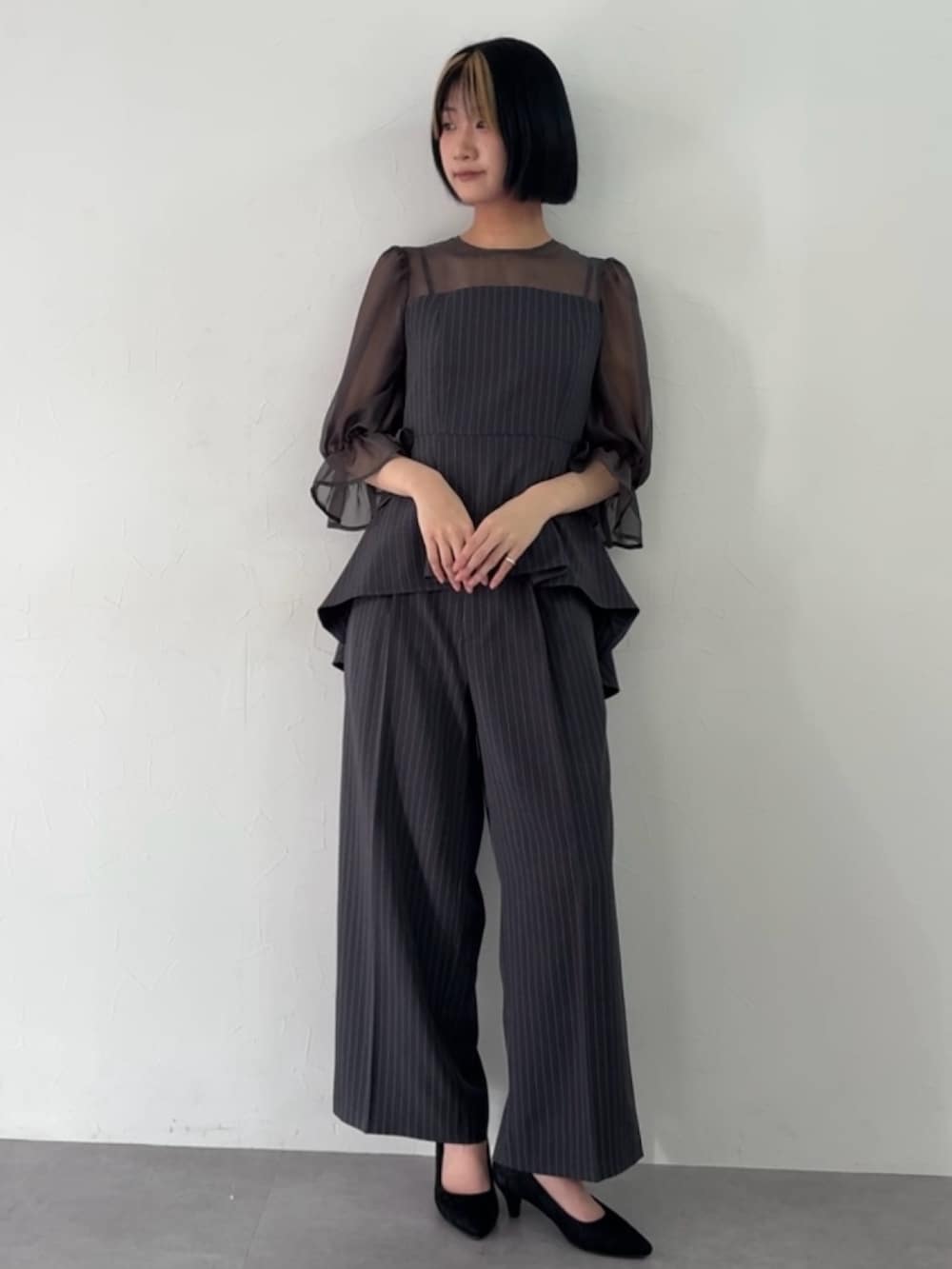 グレー系のパンツドレスを着用したレディースの春コーディネートの3枚目の写真