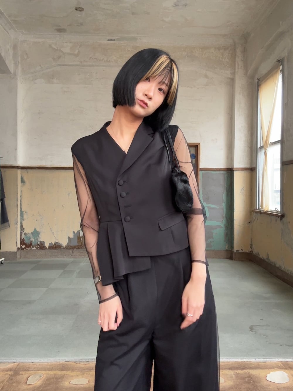 ブラック系のパンツドレスを着用したレディースの冬コーディネートの3枚目の写真