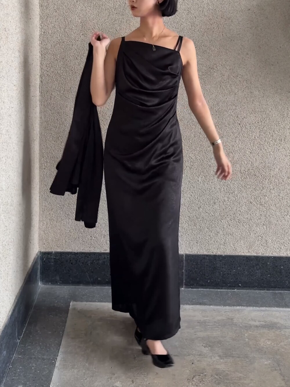 ブラック系のドレスを着用したレディースの春コーディネートの2枚目の写真