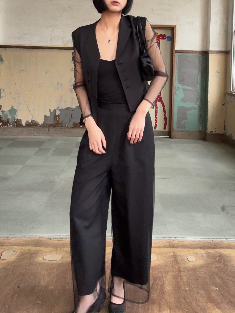 ブラック系のパンツドレスを着用したレディースの冬コーディネートの2枚目の写真