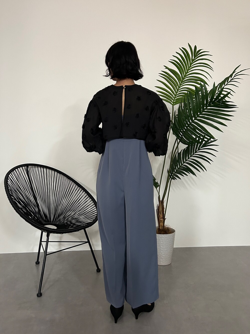 ブラック系のパンツドレスを着用したレディースの秋コーディネートの2枚目の写真