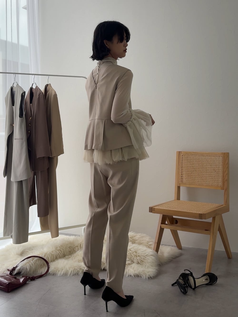 ベージュ系のパンツドレス、ホワイト系のシャツ/ブラウスを着用したレディースの冬コーディネートの3枚目の写真