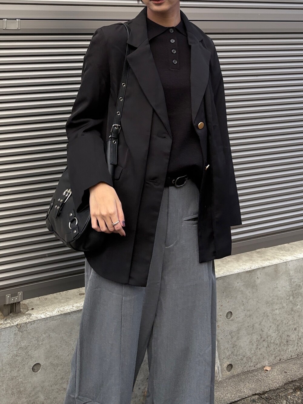 ブラック系のテーラードジャケット、ブラック系のニット/セーター、グレー系のスラックスを着用したレディースの冬コーディネートの3枚目の写真