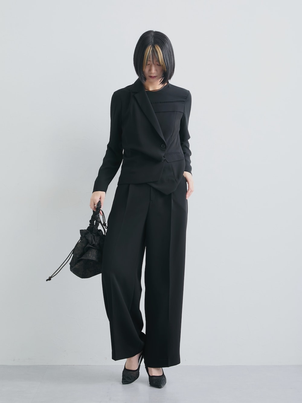 ブラック系のスーツセットを着用したレディースの春コーディネートの2枚目の写真