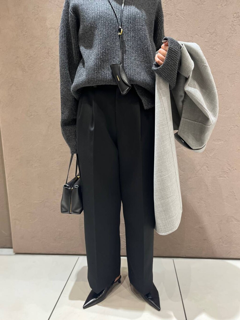 グレー系のその他アウター、グレー系のニット/セーター、ブラック系のスラックスを着用したレディースの秋コーディネートの7枚目の写真