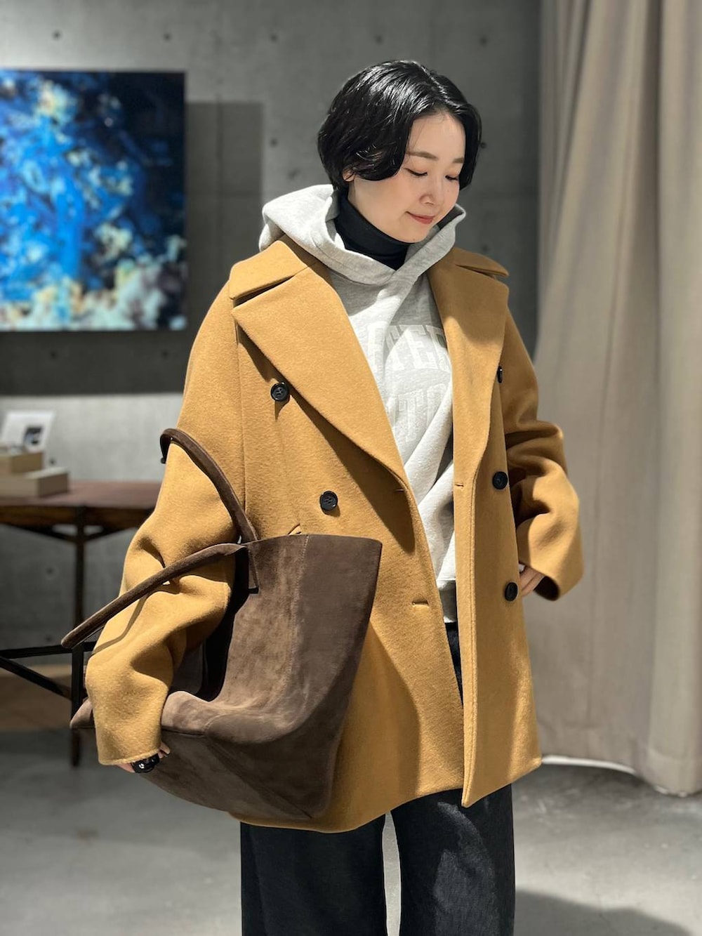 グレー系のスラックス、グレー系のパーカー、ブラック系のニット/セーターを着用したレディースの秋コーディネートの5枚目の写真