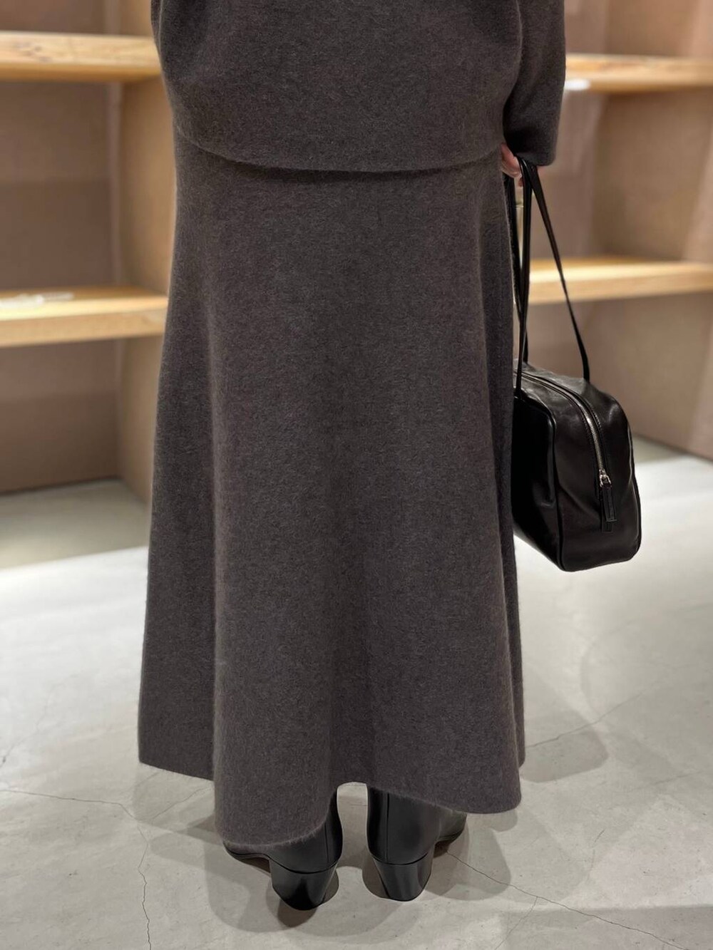 グレー系のニット/セーター、グレー系のスカートを着用したレディースの秋コーディネートの8枚目の写真