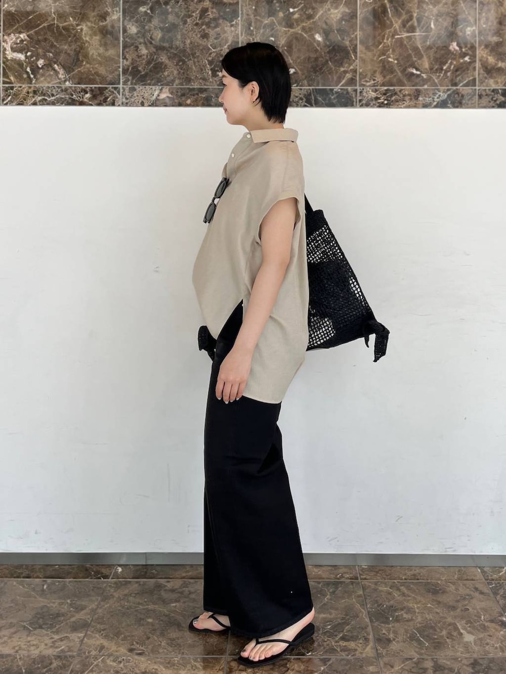 ベージュ系のシャツ/ブラウス、ブラック系のトートバッグ、ブラック系のサンダルを着用したレディースの春コーディネートの3枚目の写真