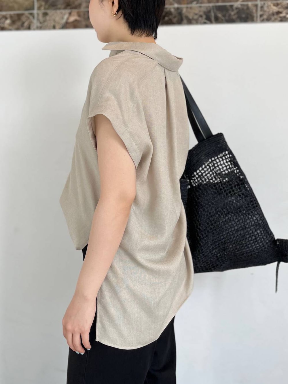 ベージュ系のシャツ/ブラウス、ブラック系のトートバッグ、ブラック系のサンダルを着用したレディースの春コーディネートの7枚目の写真