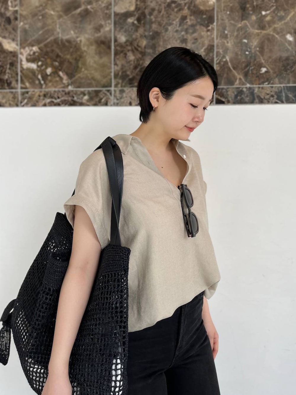 ベージュ系のシャツ/ブラウス、ブラック系のトートバッグ、ブラック系のサンダルを着用したレディースの春コーディネートの6枚目の写真