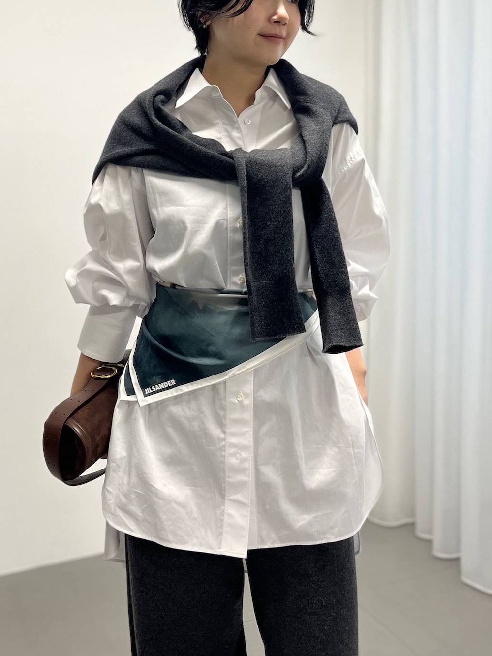 ホワイト系のシャツ/ブラウス、グレー系のその他パンツ、グレー系のストール/ショールを着用したレディースの秋コーディネートの3枚目の写真
