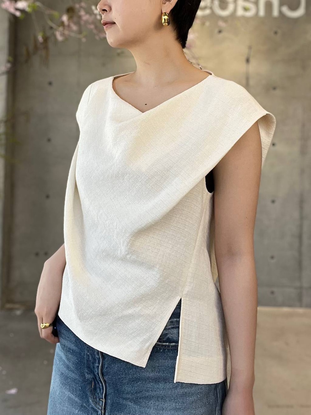 ブルー系のデニムパンツ、ホワイト系のシャツ/ブラウス、ベージュ系のナイロンジャケットを着用したレディースの春コーディネートの6枚目の写真