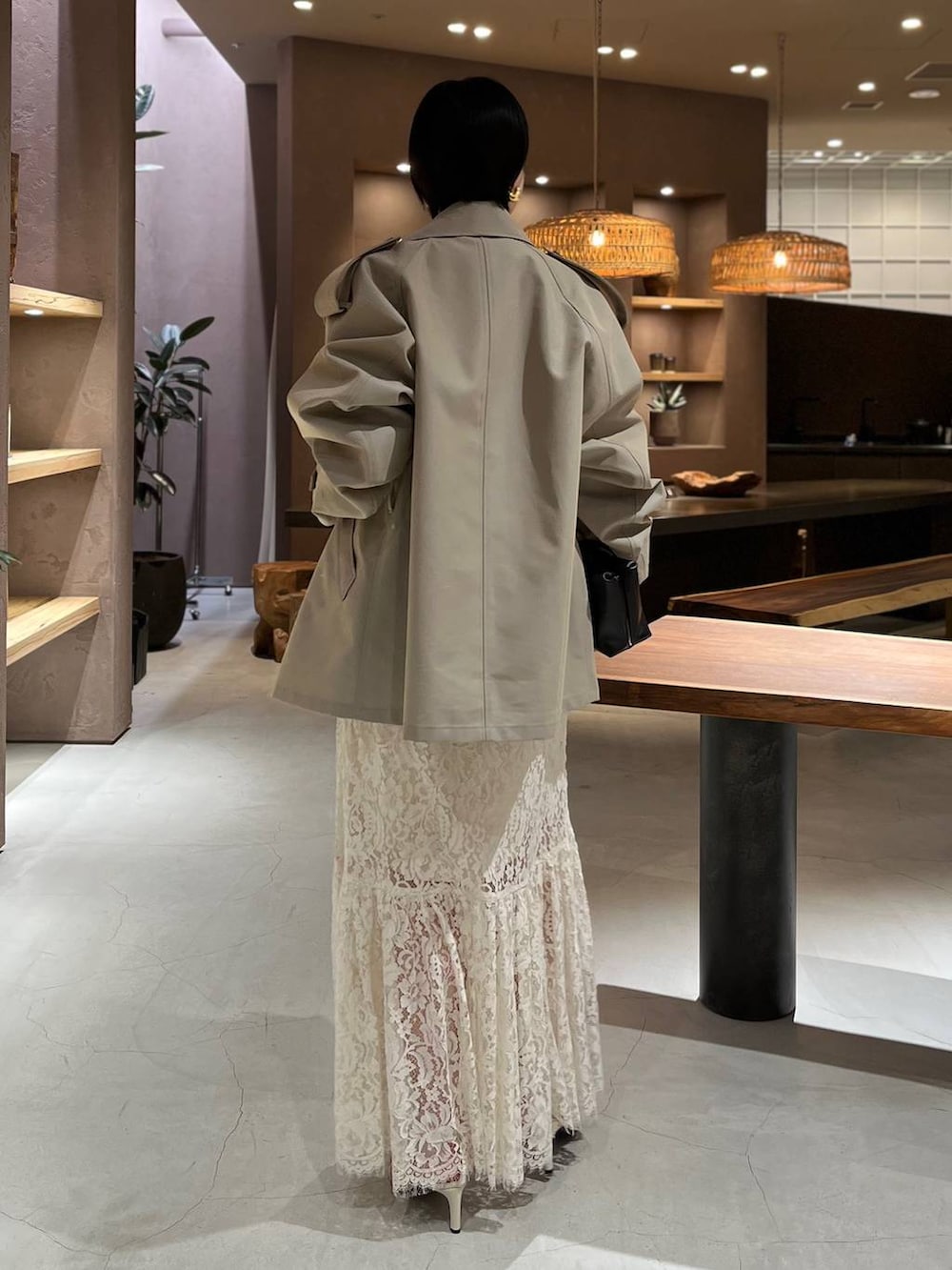 ベージュ系のトレンチコート、ホワイト系のスカート、ブラック系のニット/セーターを着用したレディースの冬コーディネートの5枚目の写真