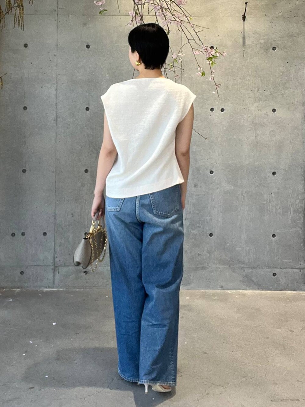 ブルー系のデニムパンツ、ホワイト系のシャツ/ブラウス、ベージュ系のナイロンジャケットを着用したレディースの春コーディネートの3枚目の写真
