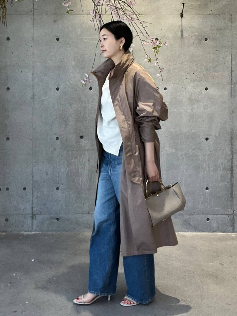 ブルー系のデニムパンツ、ホワイト系のシャツ/ブラウス、ベージュ系のナイロンジャケットを着用したレディースの春コーディネートの5枚目の写真