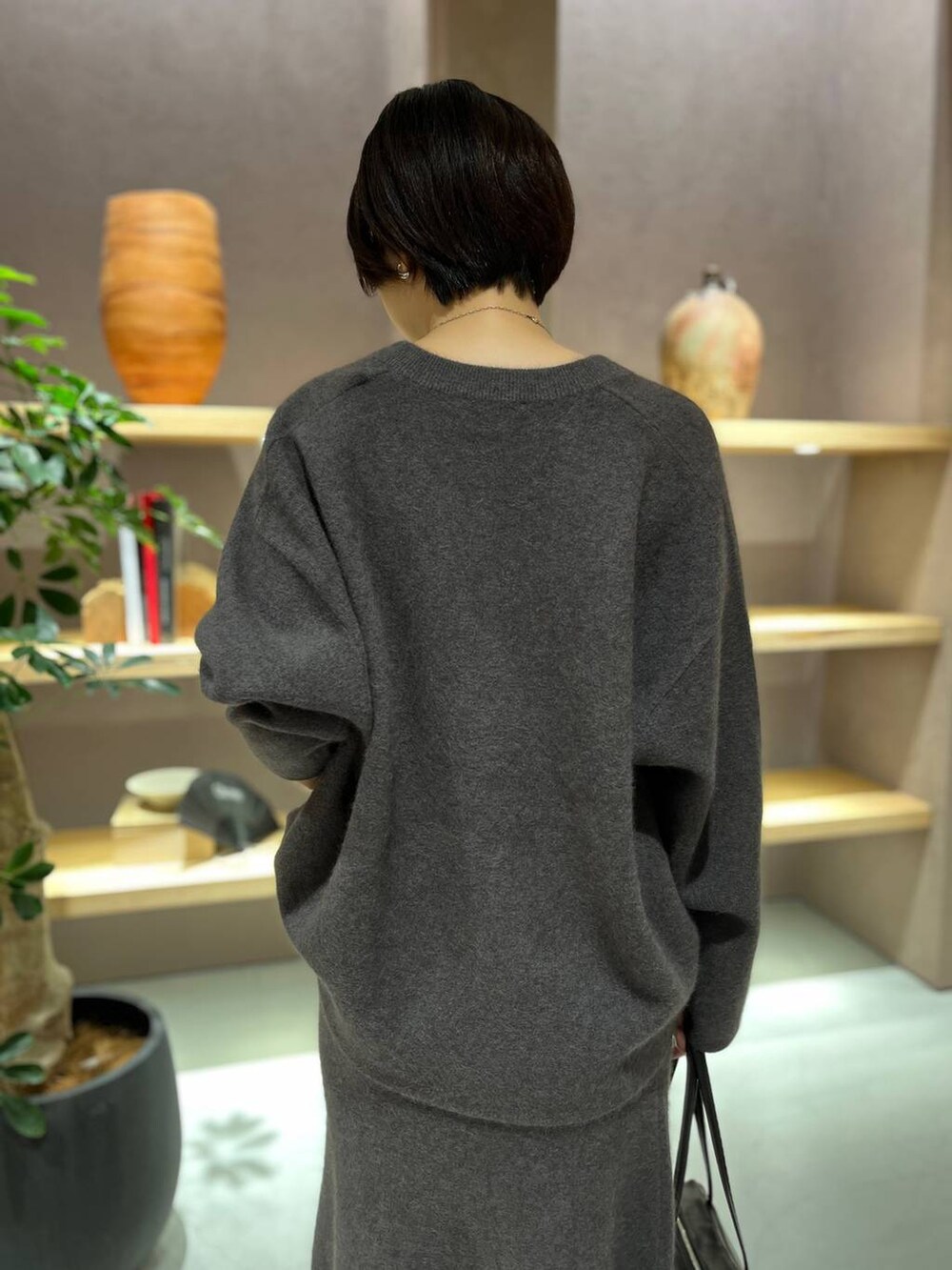 グレー系のニット/セーター、グレー系のスカートを着用したレディースの秋コーディネートの5枚目の写真