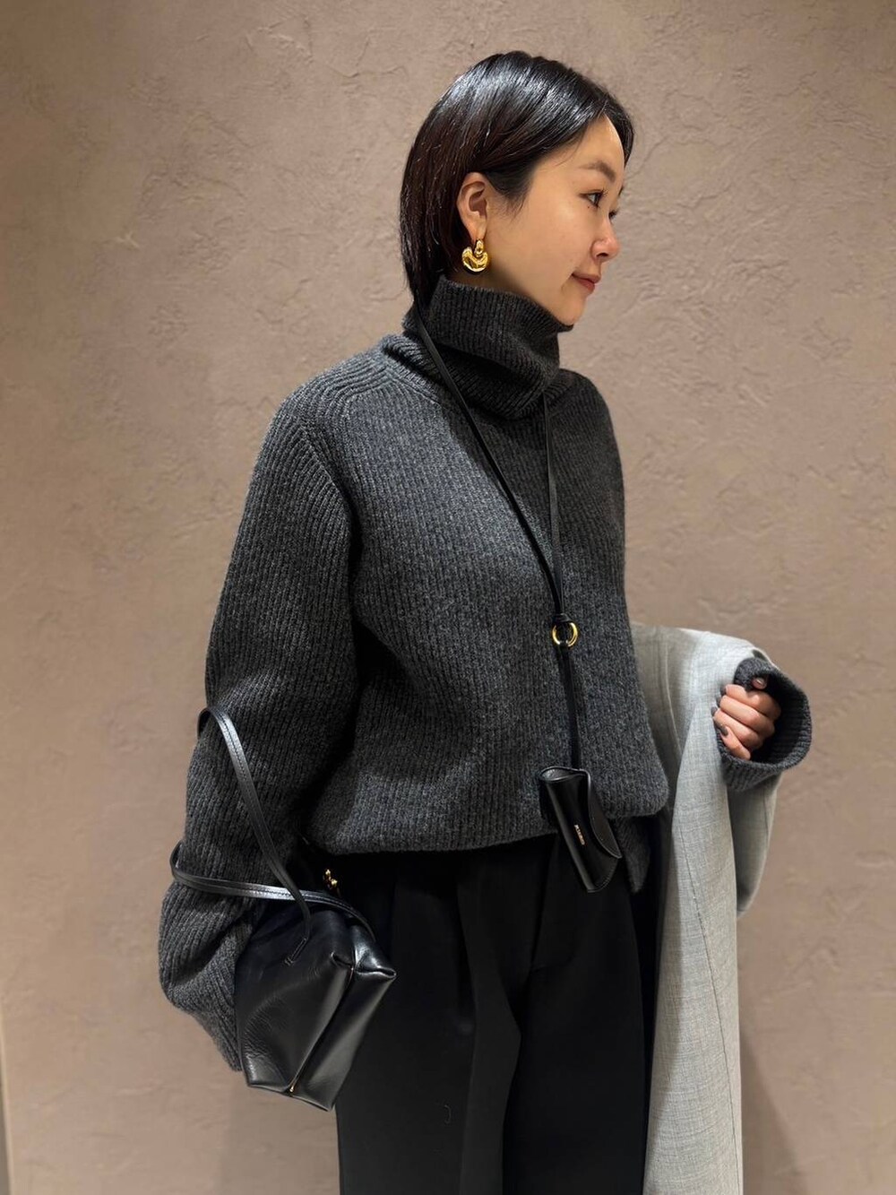 グレー系のその他アウター、グレー系のニット/セーター、ブラック系のスラックスを着用したレディースの秋コーディネートの9枚目の写真