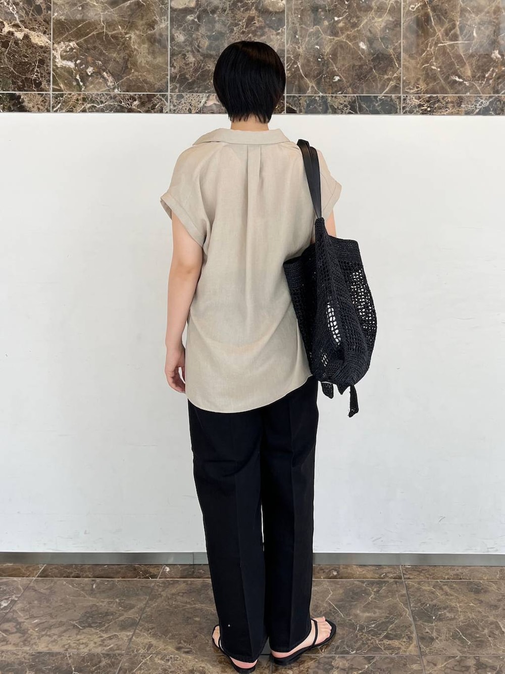 ベージュ系のシャツ/ブラウス、ブラック系のトートバッグ、ブラック系のサンダルを着用したレディースの春コーディネートの4枚目の写真