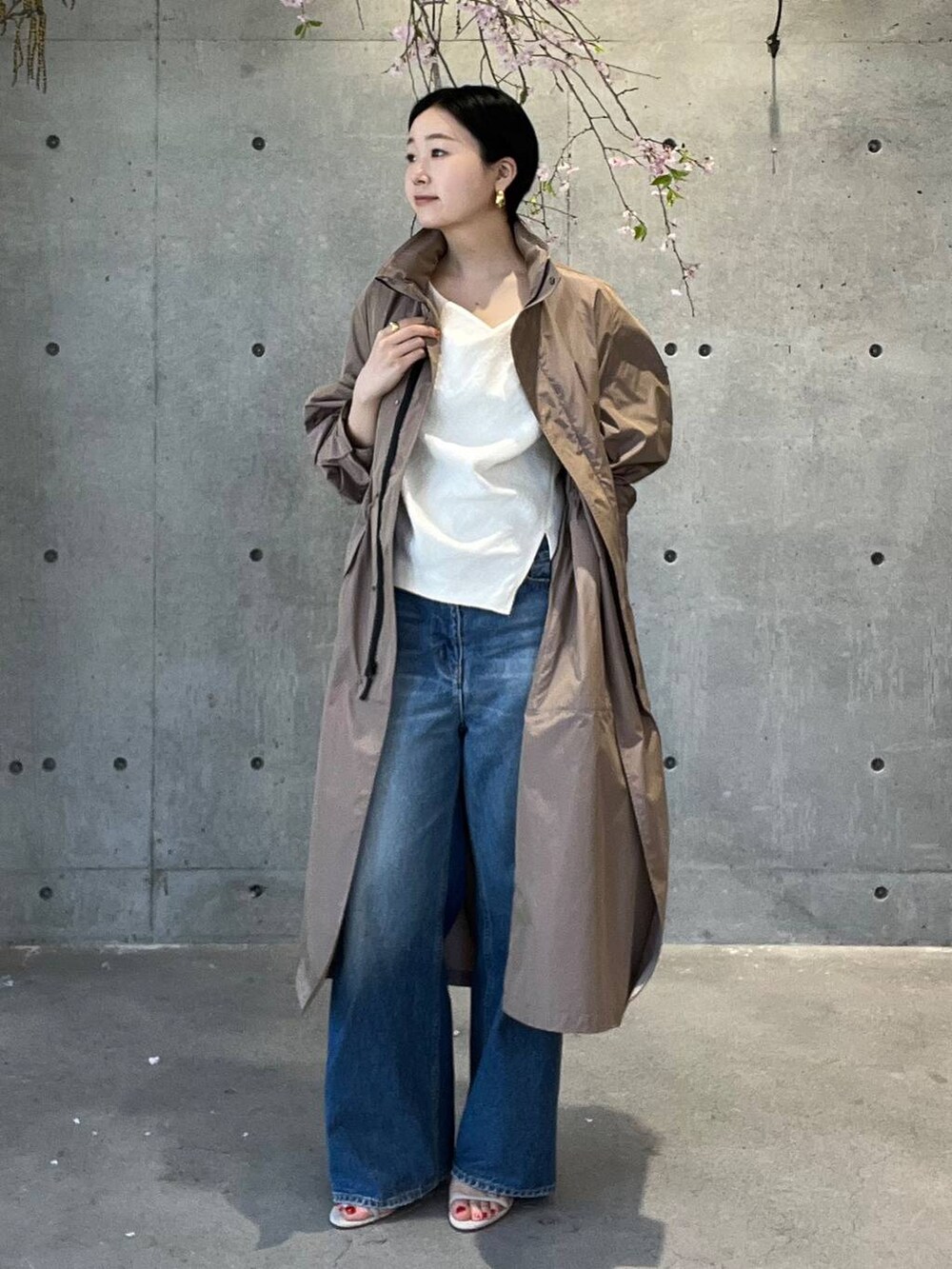 ブルー系のデニムパンツ、ホワイト系のシャツ/ブラウス、ベージュ系のナイロンジャケットを着用したレディースの春コーディネートの4枚目の写真