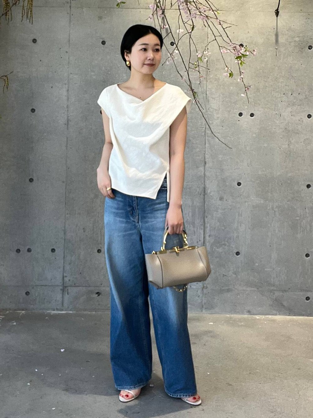 ブルー系のデニムパンツ、ホワイト系のシャツ/ブラウス、ベージュ系のナイロンジャケットを着用したレディースの春コーディネートの2枚目の写真