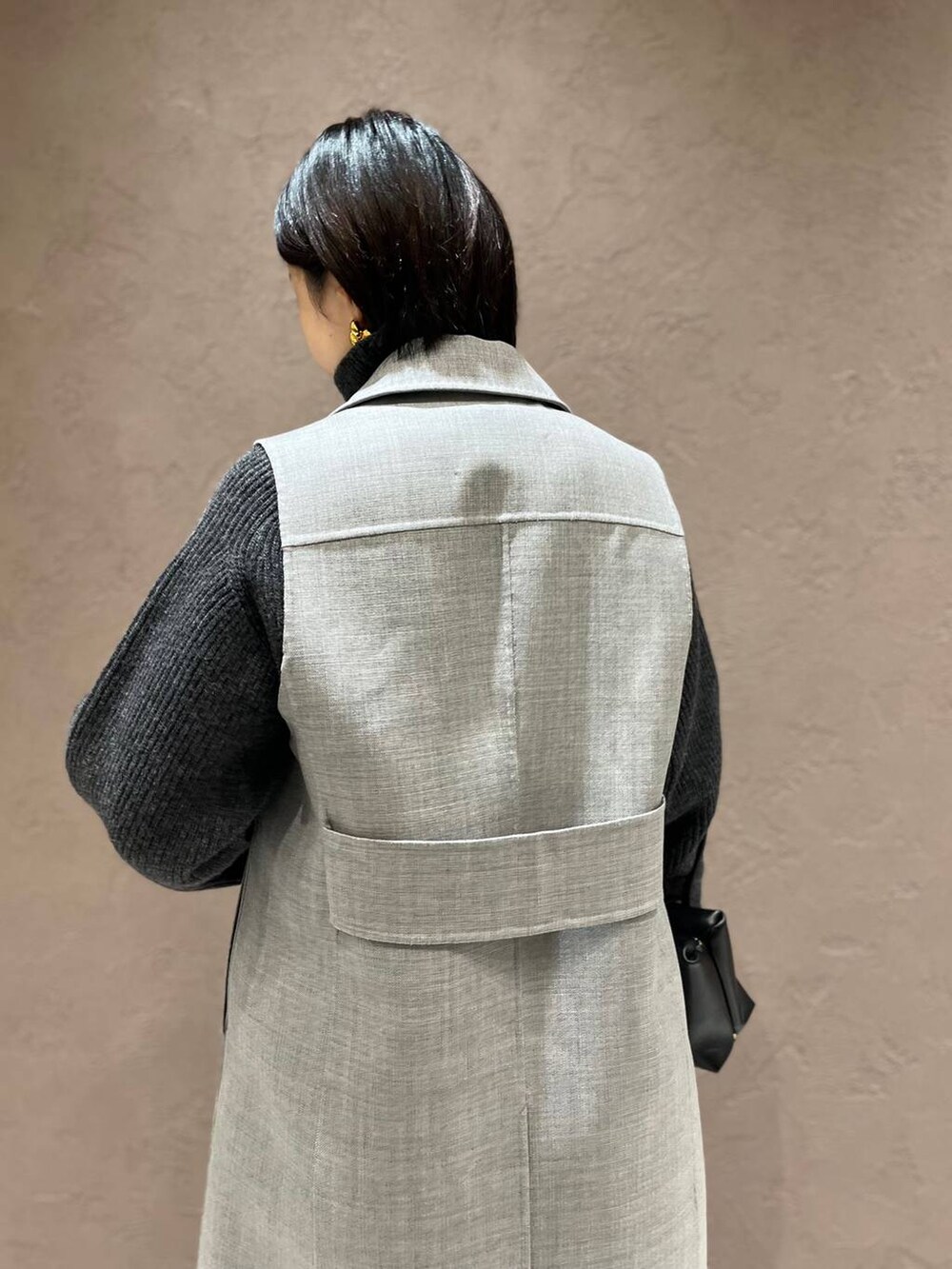 グレー系のその他アウター、グレー系のニット/セーター、ブラック系のスラックスを着用したレディースの秋コーディネートの5枚目の写真