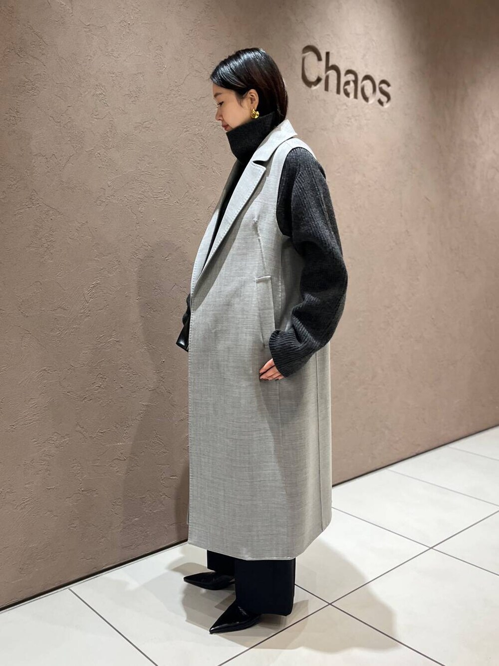 グレー系のその他アウター、グレー系のニット/セーター、ブラック系のスラックスを着用したレディースの秋コーディネートの2枚目の写真