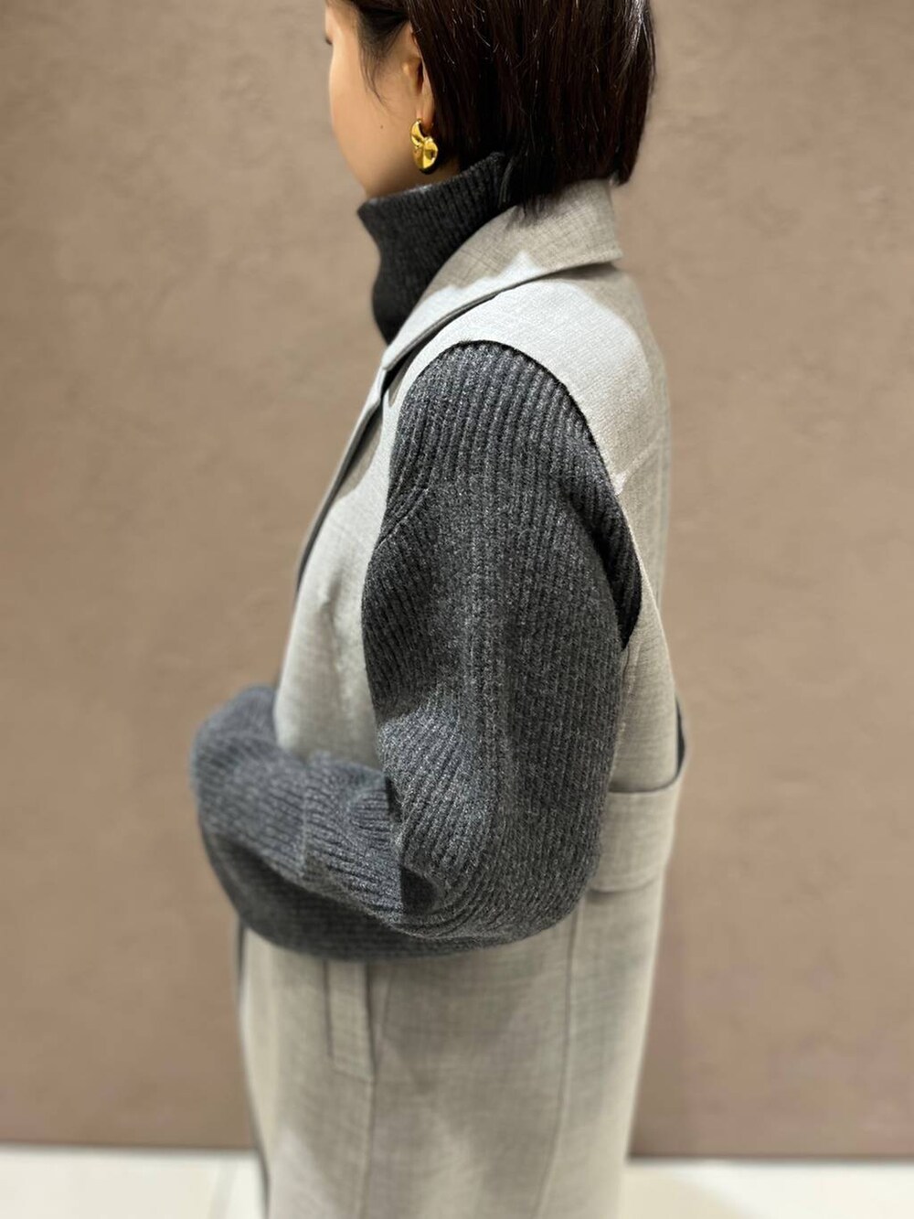 グレー系のその他アウター、グレー系のニット/セーター、ブラック系のスラックスを着用したレディースの秋コーディネートの6枚目の写真