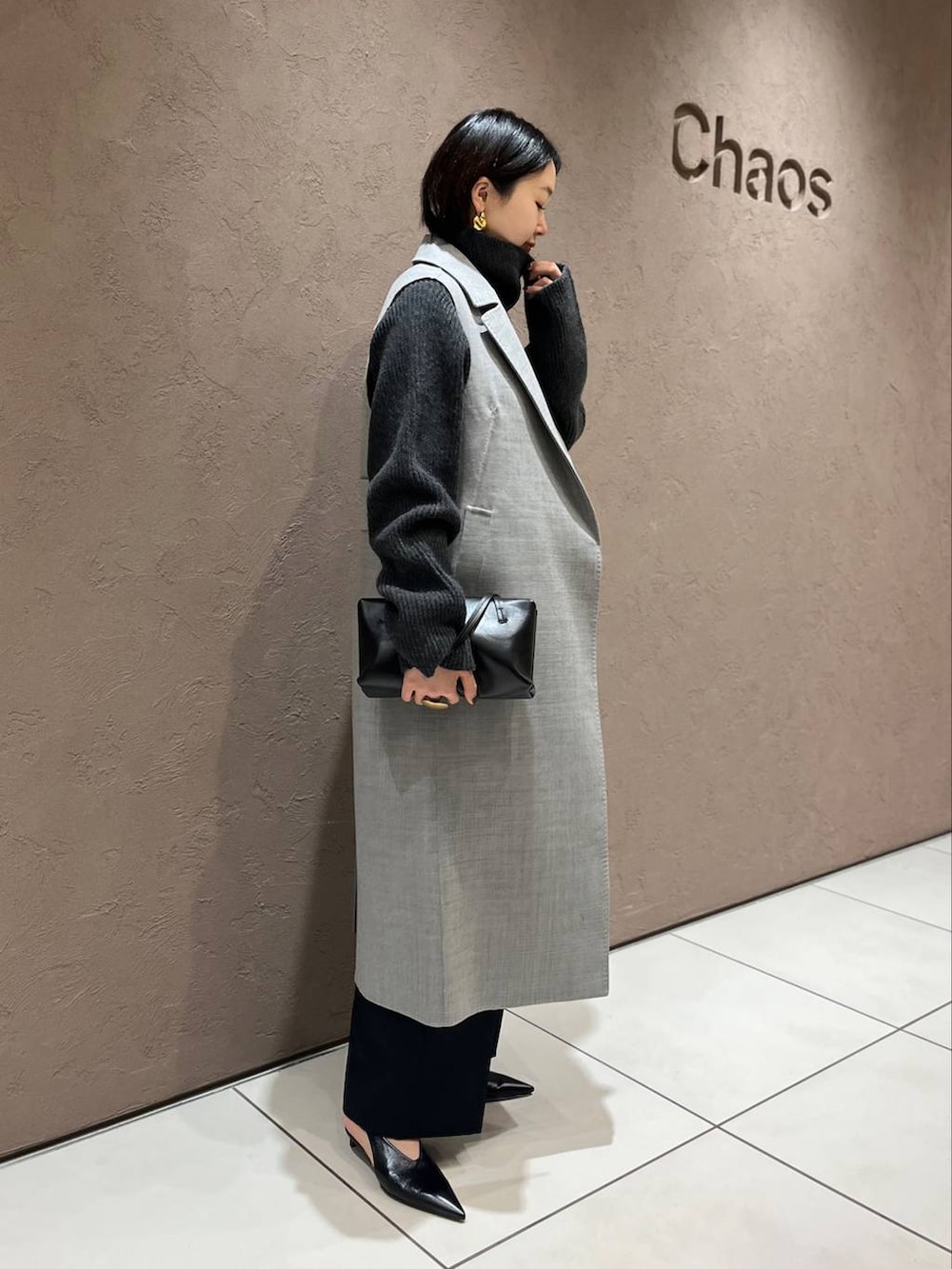 グレー系のその他アウター、グレー系のニット/セーター、ブラック系のスラックスを着用したレディースの秋コーディネートの3枚目の写真