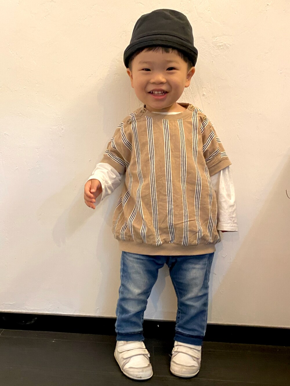 ベージュ系のワンピース/ドレス、ホワイト系のデニムパンツ、ホワイト系のトップスを着用したキッズの春コーディネートの2枚目の写真