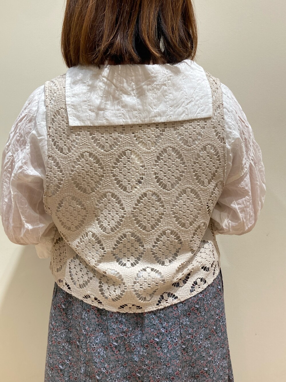 ブルー系のスカート、ホワイト系のベスト、ホワイト系のシャツ/ブラウスを着用したレディースの夏コーディネートの3枚目の写真