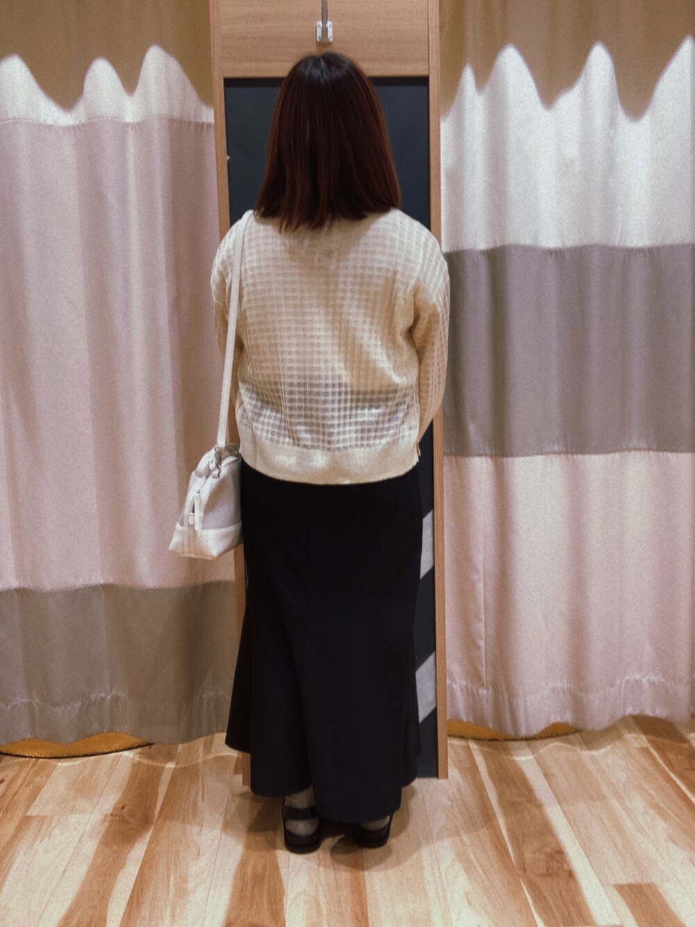 ブラック系のスカート、ホワイト系のバッグ、ホワイト系のTシャツ/カットソーを着用したレディースの春コーディネートの3枚目の写真